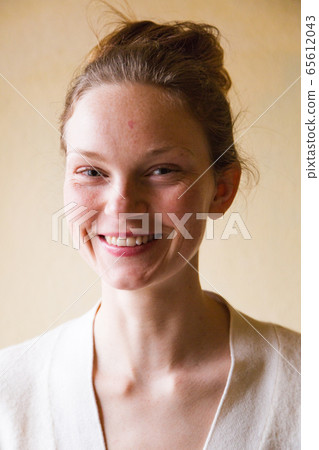 Portrait of happy woman with topknot on her head Portrait of happy woman with topknot on her head 65612043