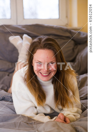 Young woman in knitted sweater and bikini in bed Young woman in knitted sweater and bikini in bed 65612054
