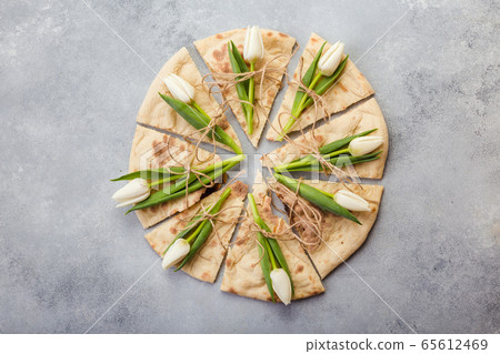 creative peace of pizza with flowers tulips in plate 65612469