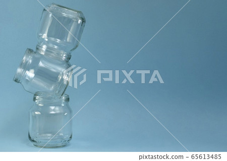 Vertical row of crooked glass jars on top of each Vertical row of crooked glass jars on top of each 65613485