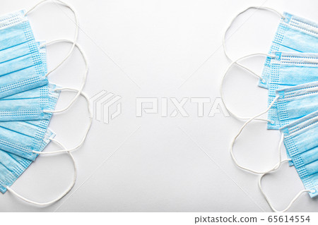 Several medical blue disposable protective masks one on top of other in form of fan on white background. surgical dressing closes mouth and nose. Healthcare, medicine, covid-19, epidemic concept. Several medical blue disposable protective masks one on top of other in form of fan on white background. surgical dressing closes mouth and nose. Healthcare, medicine, covid-19, epidemic concept. 65614554