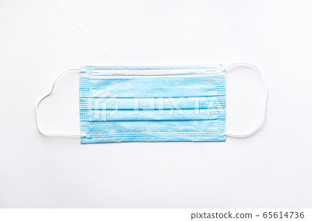 Medical blue disposable protective mask on a white background copy space. A surgical dressing closes the mouth and nose. Healthcare, medicine, covid-19, epidemic concept. Medical blue disposable protective mask on a white background copy space. A surgical dressing closes the mouth and nose. Healthcare, medicine, covid-19, epidemic concept. 65614736