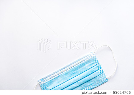 Medical blue disposable protective mask on a white background copy space. A surgical dressing closes the mouth and nose. Healthcare, medicine, covid-19, epidemic concept. Medical blue disposable protective mask on a white background copy space. A surgical dressing closes the mouth and nose. Healthcare, medicine, covid-19, epidemic concept. 65614766