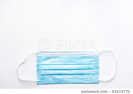 Medical blue disposable protective mask on a white background copy space. A surgical dressing closes the mouth and nose. Healthcare, medicine, covid-19, epidemic concept. Medical blue disposable protective mask on a white background copy space. A surgical dressing closes the mouth and nose. Healthcare, medicine, covid-19, epidemic concept. 65614770
