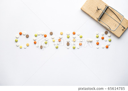 covid-19 inscription with pills and capsules and wooden mousetrap in layout on a white background copy space. Coronavirus, medicine and health, safety concept. covid-19 inscription with pills and capsules and wooden mousetrap in layout on a white background copy space. Coronavirus, medicine and health, safety concept. 65614785