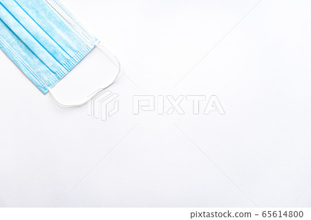 Medical blue disposable protective mask on a white background copy space. A surgical dressing closes the mouth and nose. Healthcare, medicine, covid-19, epidemic concept. 65614800