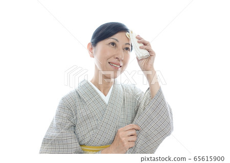 一名中年婦女在夏天穿著和服，面帶微笑的手帕遮住了陽光 65615900