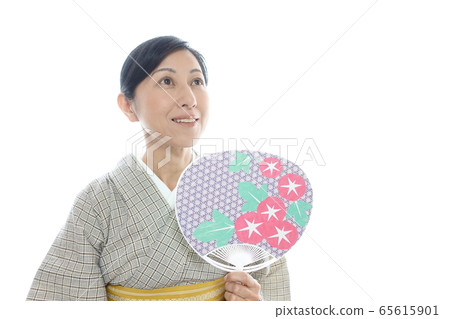 An image of a middle-aged woman in a summer kimono looking at fireworks and fireflies with a smiling fan An image of a middle-aged woman in a summer kimono looking at fireworks and fireflies with a smiling fan 65615901