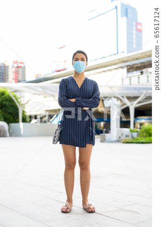 Full body shot of young Asian businesswoman wearing mask for protection from corona virus outbreak 65617124