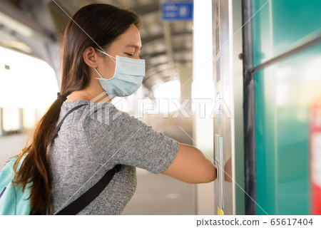 Young Asian woman with mask pressing elevator button with elbow to prevent spreading the corona Young Asian woman with mask pressing elevator button with elbow to prevent spreading the corona 65617404