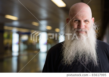 Face of mature handsome bald bearded man at the subway train station Face of mature handsome bald bearded man at the subway train station 65617995