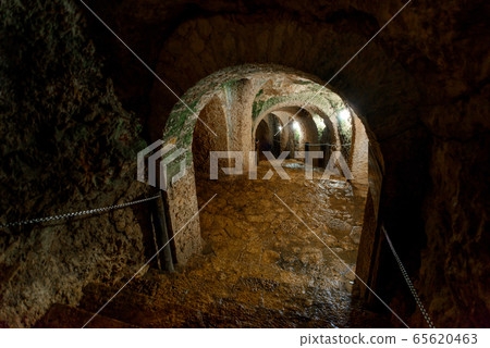 The tunnel cut through the rock. Cenote Ecoturistico X-cajum with clear water. 65620463