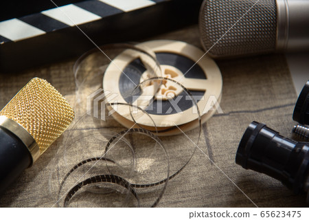 Film reel, movie clapperboard, two microphones and 65623475