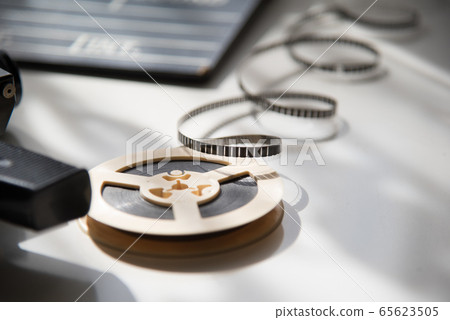 Unwound 8mm film strip on a light background with Unwound 8mm film strip on a light background with 65623505