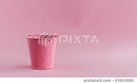 Mini colored tin pail or bucket on pink background 65624080