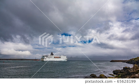 Huge cruise ship leaving the port under the clouds Huge cruise ship leaving the port under the clouds 65628199