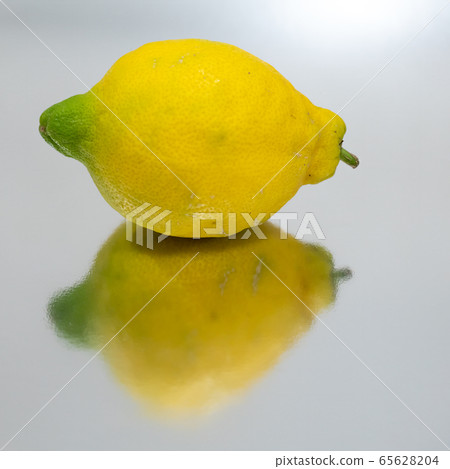 Bright yellow lemon isolated and reflected 65628204