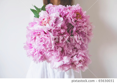 Woman holding beautiful bunch of fresh pink peony flowers. Woman holding beautiful bunch of fresh pink peony flowers. 65630031