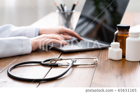 Modern technologies for work of doctor. Woman in white coat working at laptop 65631165