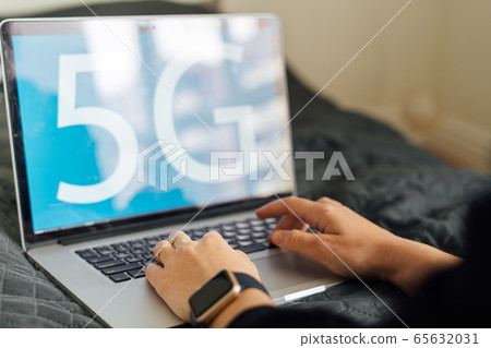 Blue background with 5G sign on laptop and person working. Fast mobile network. Evolution in Blue background with 5G sign on laptop and person working. Fast mobile network. Evolution in 65632031