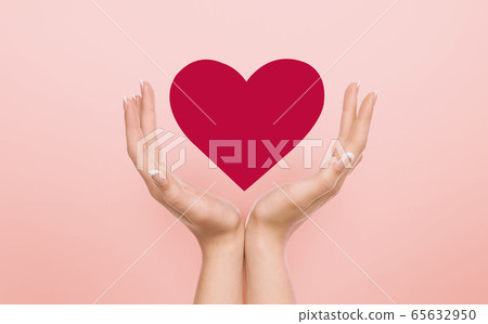 Volunteering concept. Female hands guarding red heart over pink background, collage 65632950