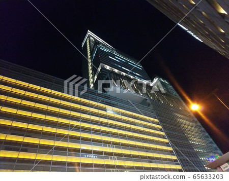 Night view of a skyscraper characterized by yellow lines with horizontal stripes Night view of a skyscraper characterized by yellow lines with horizontal stripes 65633203