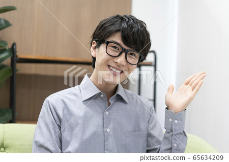 一個年輕人看著鏡頭微笑 65634209