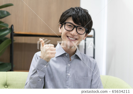 一個年輕人看著鏡頭微笑 65634211