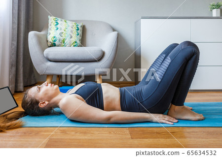 Young woman practicing online class yoga at home 65634532