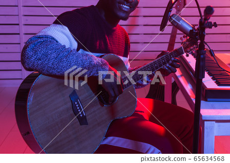 African american professional musician recording guitar in digital studio at home, music production technology concept, close-up. 65634568
