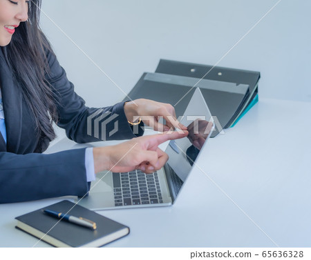 Close-up businessman's hand pointing on laptop screen over white desk at workplace. Close-up businessman's hand pointing on laptop screen over white desk at workplace. 65636328