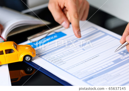 Male arm in suit offer insurance form clipped to pad 65637145