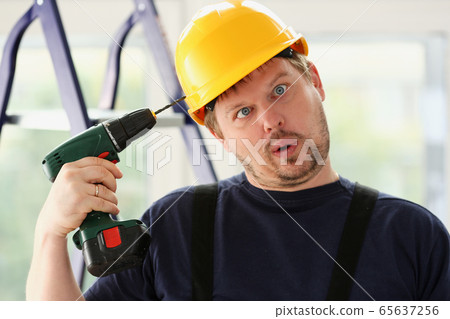 Idiot worker using electric drill portrait 65637256