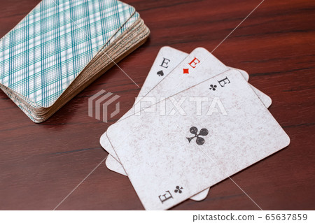Play cards, three aces and a deck on the table. Card Solitaire 65637859