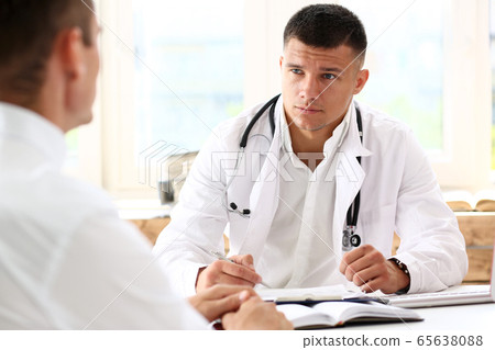 Handsome smiling male doctor hold silver pen 65638088