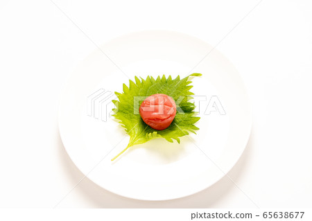 Umeboshi is placed on a large leaf (Aojisono leaf). (White plate / white background) Umeboshi is placed on a large leaf (Aojisono leaf). (White plate / white background) 65638677