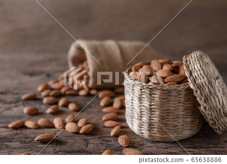 Almond in basket on blurred wooden background Almond in basket on blurred wooden background 65638886