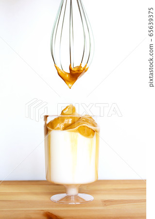 Dalgona coffee in transparent glass. Copy space. 65639375