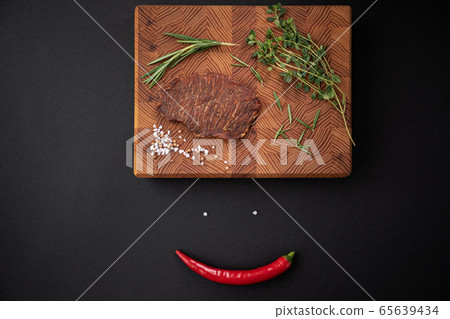 Close-up of a piece of meat on a wooden Board with spices. Restaurant menu, a series of photos of different dishes Close-up of a piece of meat on a wooden Board with spices. Restaurant menu, a series of photos of different dishes 65639434