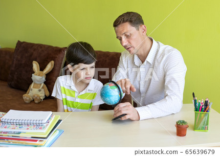 Boy with father doing homework during the coronavirus quarantine. Boy with father doing homework during the coronavirus quarantine. 65639679