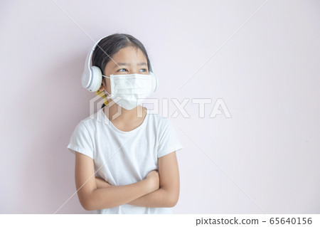 A little Asian girl wearing a medical protective 65640156