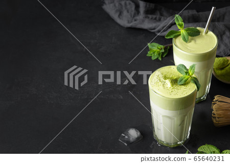 Glass of Dalgona Iced Matcha tea on black. 65640231