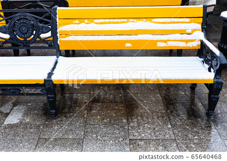 front view of yellow wooden benches under snow front view of yellow wooden benches under snow 65640468