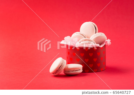 Pink french cookies macaroons on red background 65640727