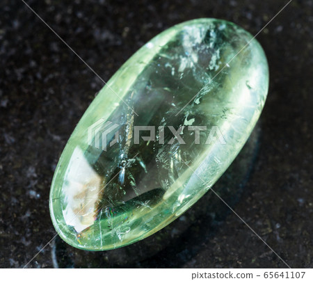 rolled Prasiolite (green quartz) rock on black 65641107