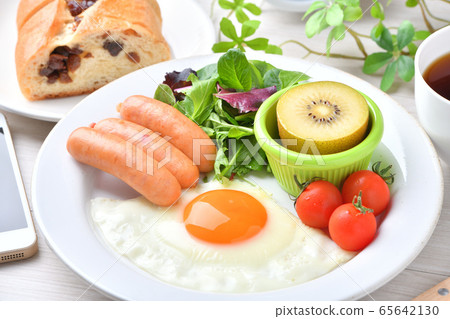 一盤早餐的圖像(西餐,煎蛋,香腸)。葡萄乾麵包,咖啡,智能手機和時鐘。 一盤早餐的圖像(西餐,煎蛋,香腸)。葡萄乾麵包,咖啡,智能手機和時鐘。 65642130