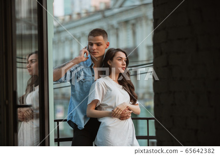 Quarantine lockdown, stay home concept - young beautiful caucasian couple enjoying new lifestyle during coronavirus worldwide health emergency 65642382