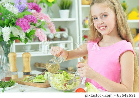 Portrait of cute girl preparing delicious fresh salad Portrait of cute girl preparing delicious fresh salad 65642651