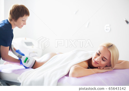 Skin care. Woman is in the process at the clinic lipomassage. 65643142