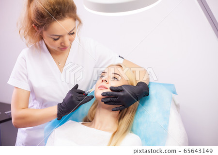 Lip Augmentation In Cosmetology Clinic. Beautiful Woman Getting Beauty Injection For Lips 65643149